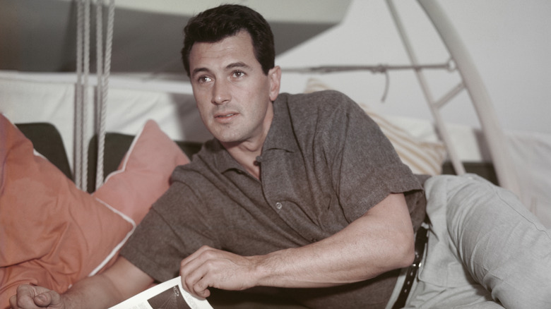 Rock Hudson levant les yeux de sa lecture