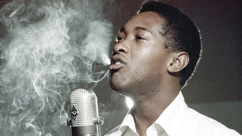 Sam Cooke avec un micro et de la fumée en arrière-plan