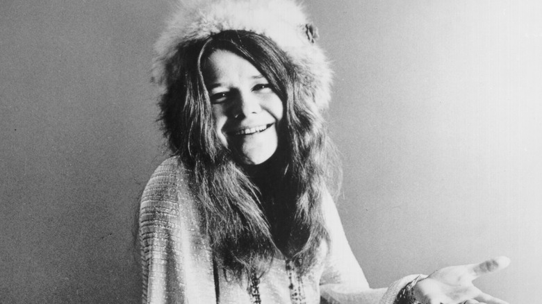 Janis Joplin souriant avec un chapeau de fourrure
