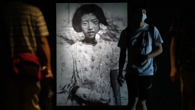 Photo d'un survivant de la bombe atomique âgé de 10 ans projetée sur le mur