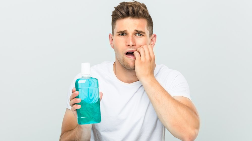 Homme inquiet avec du bain de bouche