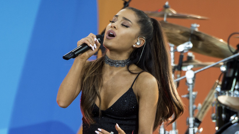 Ariana Grande chantant avec une oreillette scintillante