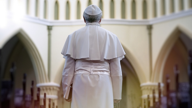 Le pape tenant une Bible dans une église