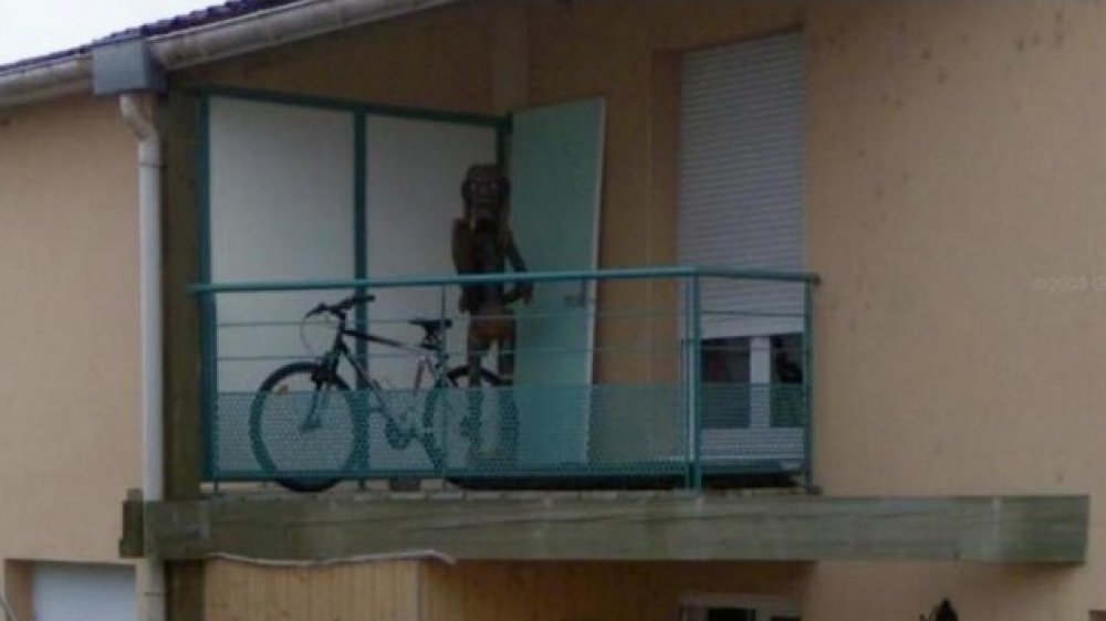 Figure étrange sur un balcon à Nancy, France, vue depuis la rue