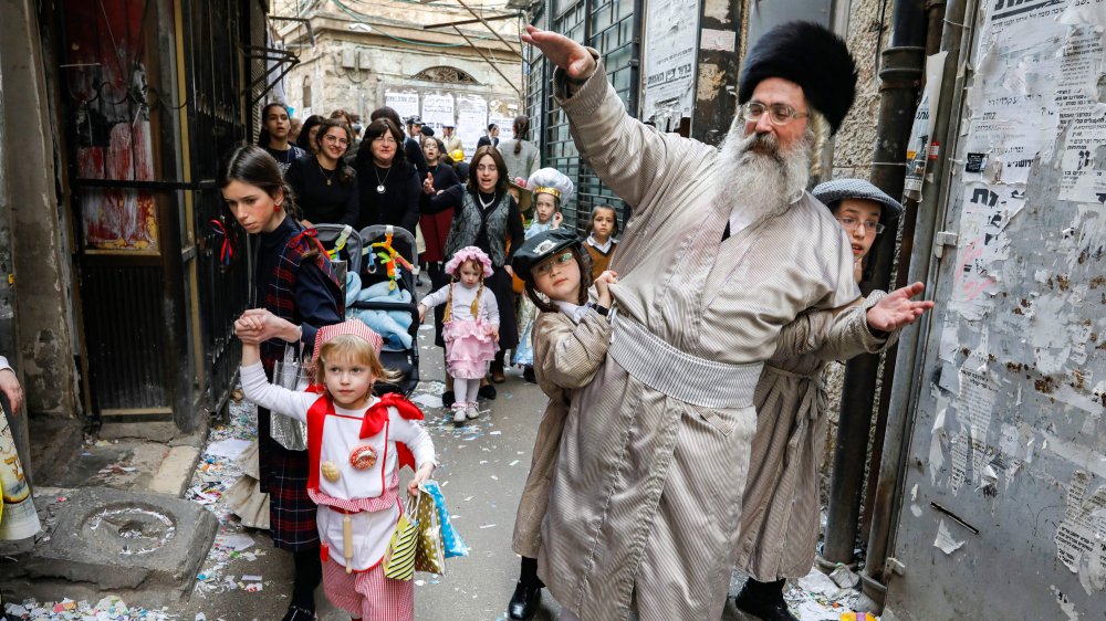 Homme juif dansant avec une foule, y compris de jeunes enfants costumés