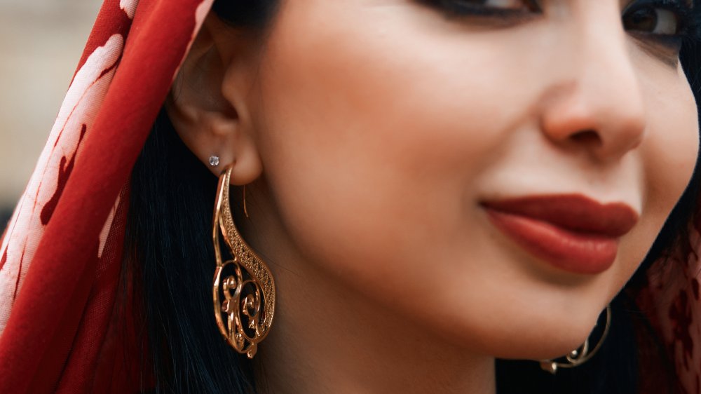 Belle femme du Moyen-Orient portant un foulard rouge et des boucles d'oreilles