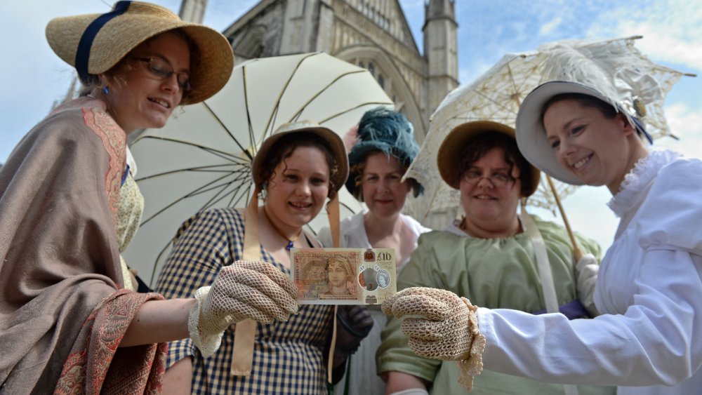 Jeunes femmes en costume d'époque avec le nouveau billet de 10 livres à l'effigie de Jane Austen