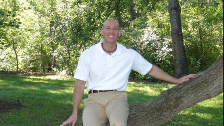 Aeryn Gillern assis dans un arbre et souriant