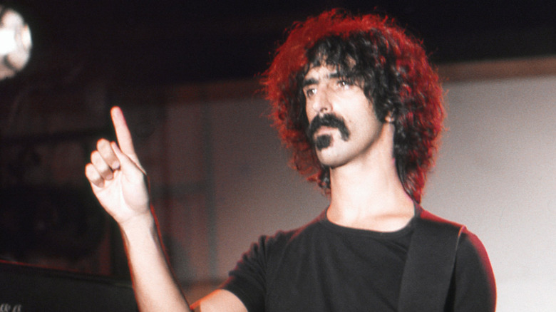 Frank Zappa sous un projecteur avec sa guitare