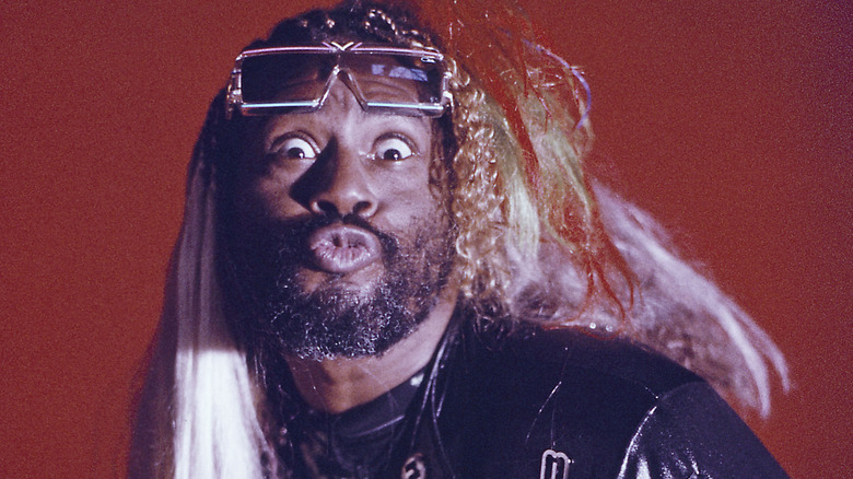 George Clinton faisant une drôle de tête sur un fond rouge