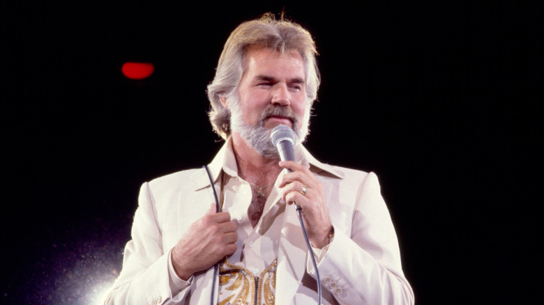 Kenny Rogers chantant avec émotion sur scène au début des années 1980