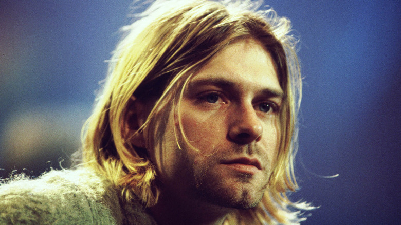 Gros plan du leader de Nirvana, Kurt Cobain, photographié devant un fond bleu