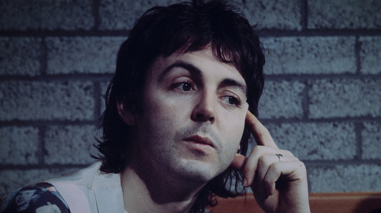Paul McCartney en pleine réflexion, le doigt sur la tempe en 1976
