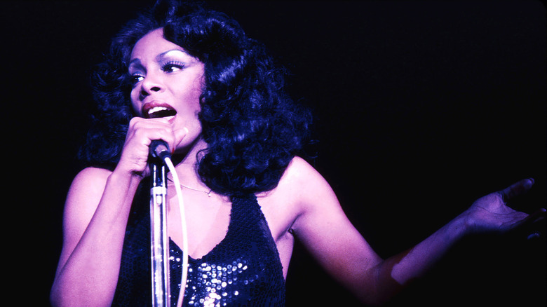 Donna Summer chantant dans un micro vêtue d'une robe à paillettes