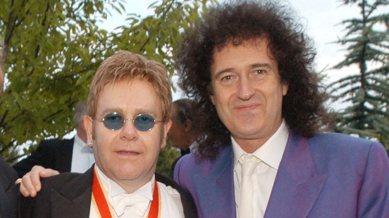 Brian May de Queen enlaçant Elton John