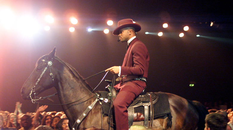 Will Smith sur un cheval avec un costume violet et un chapeau