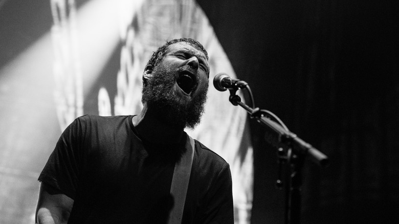 Andy Hull de Manchester Orchestra sur scène avec sa guitare