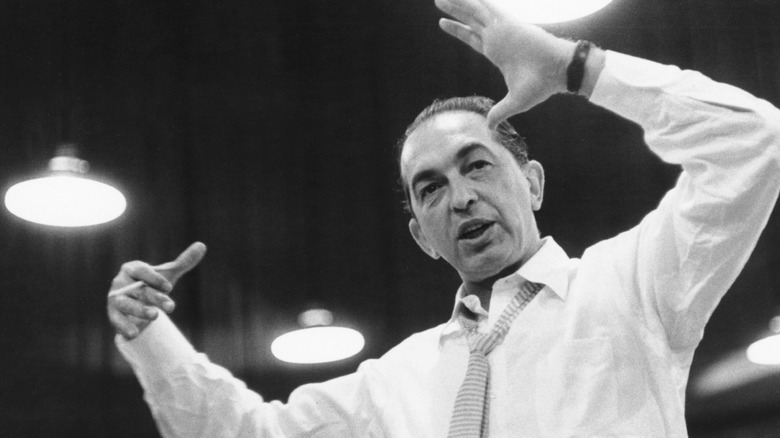 Percy Faith avec des lunettes de soleil dirigeant son orchestre en extérieur