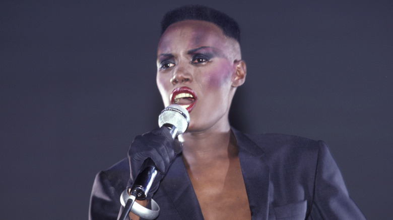 Grace Jones chantant sur scène en costume sombre