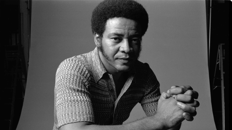 Bill Withers assis devant un fond de studio