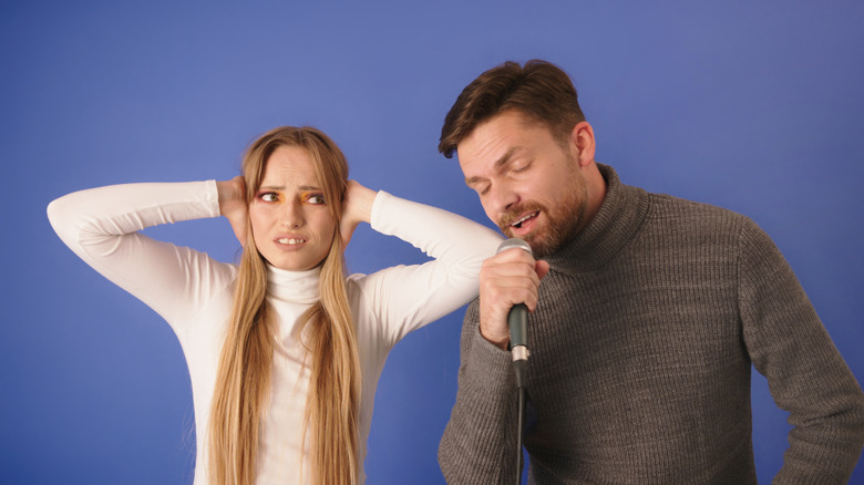 Femme agacée par un homme qui chante