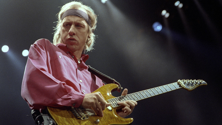 Mark Knopfler jouant de la guitare sur scène