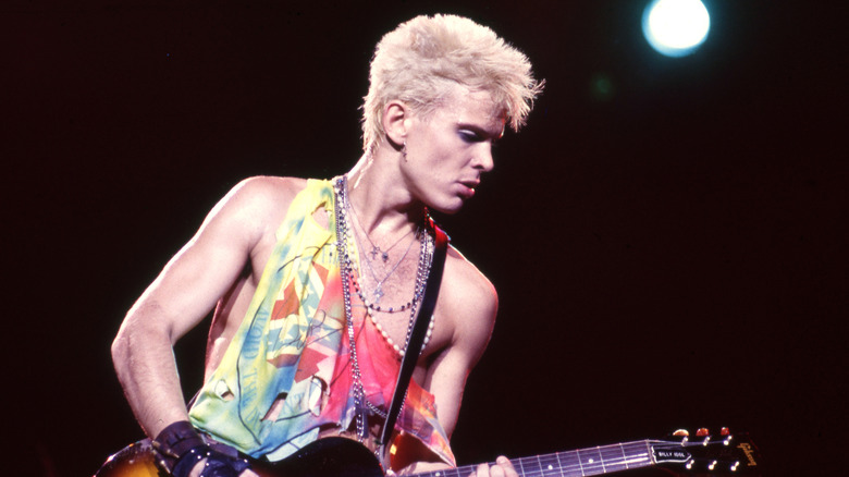Billy Idol jouant de la guitare sur scène dans les années 1980