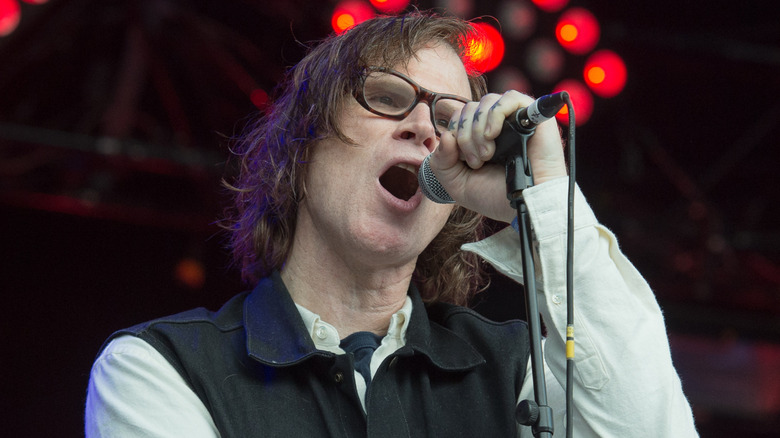 Mark Lanegan chantant sous des lumières rouges