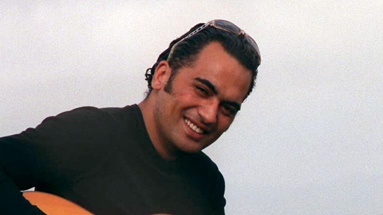 Pauly Fuemana de OMC souriant avec une guitare