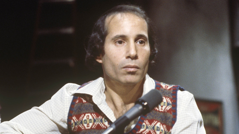 Paul Simon jouant de la guitare sur scène