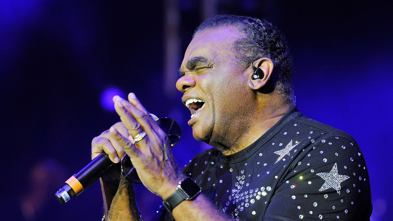 Ron Isley chantant dans un micro sur scène