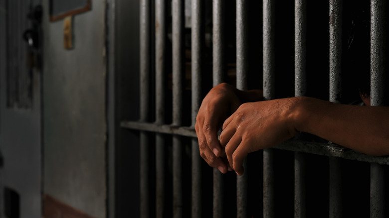 Main d'un détenu dépassant d'une cellule de prison