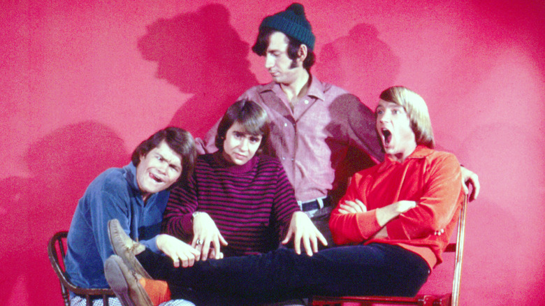 Les quatre membres des Monkees sur fond rouge