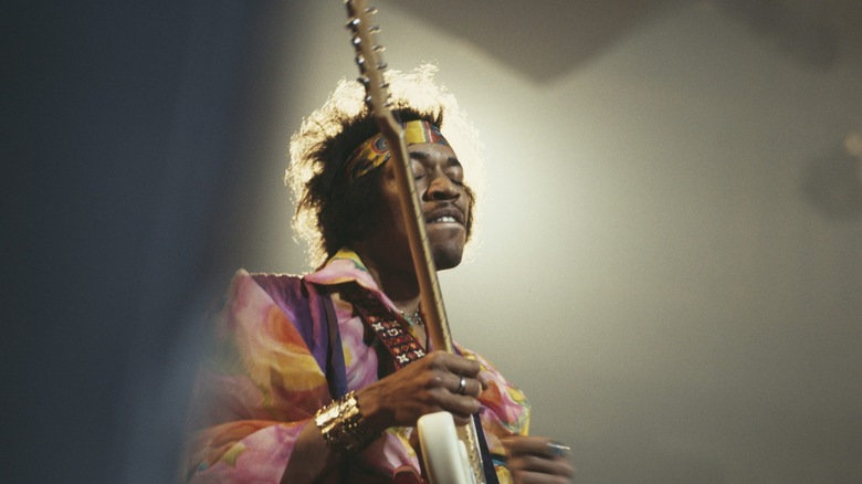 Jimi Hendrix jouant de la guitare sous un projecteur