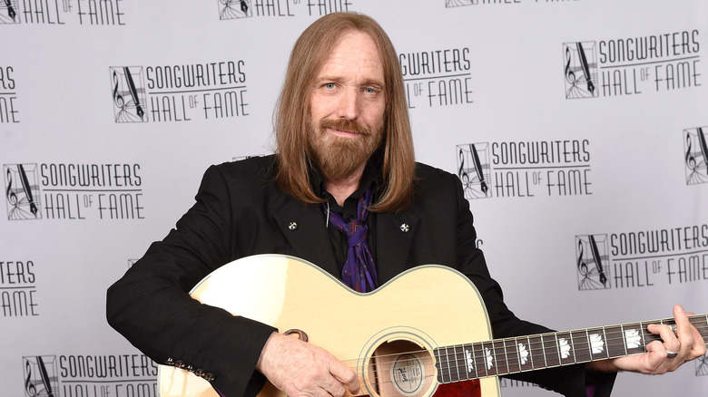 Tom Petty souriant avec une guitare