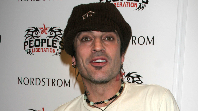 Tommy Lee avec un chapeau et un collier