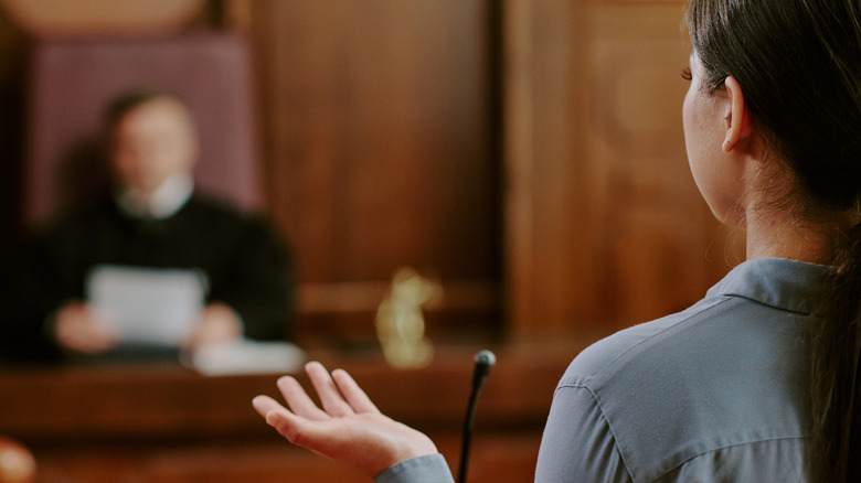 Vue de dos d'un témoin à la barre face à un juge