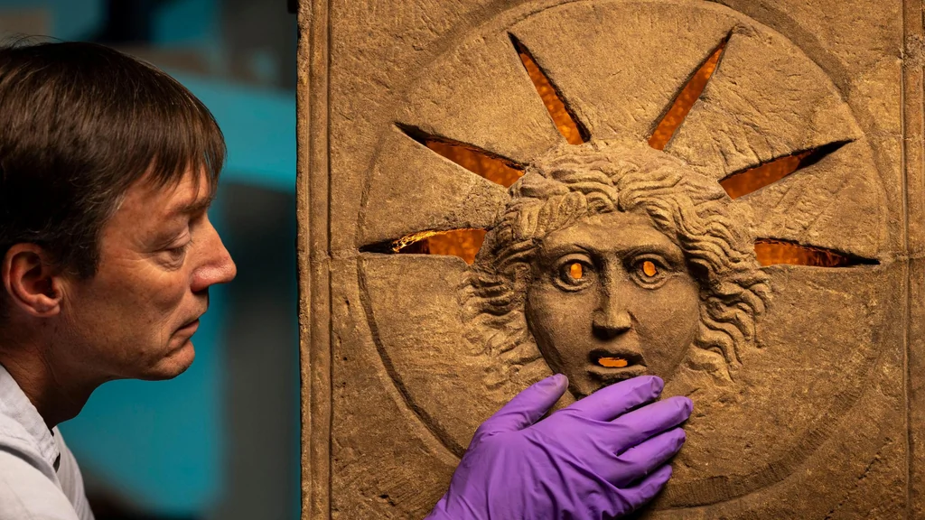 Conservateur des Musées nationaux d'Écosse examinant l'un des autels romains de Mithra découverts à Inveresk