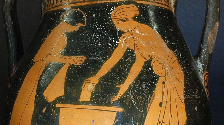 Vase grec ancien montrant une femme lavant du linge