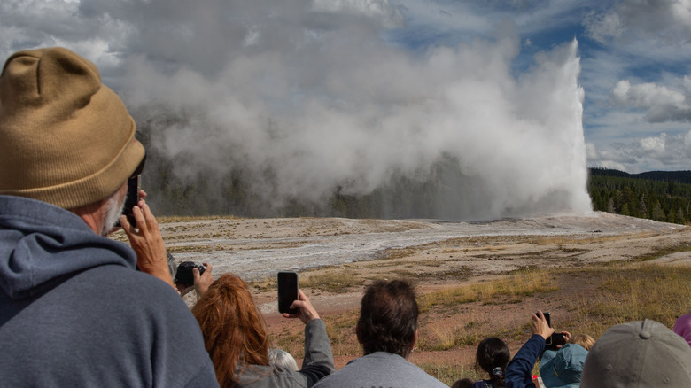 Touristes observant un geyser à Yellowstone