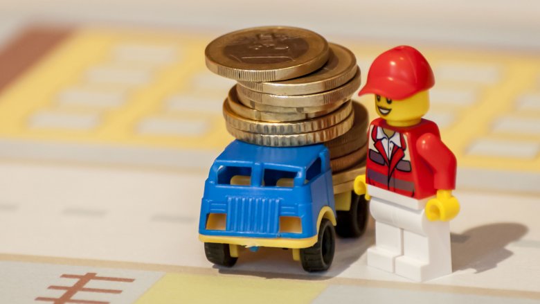 Employé Lego avec des pièces de monnaie