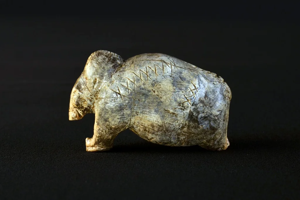 Figurine de mammouth portant des croix et des points gravés