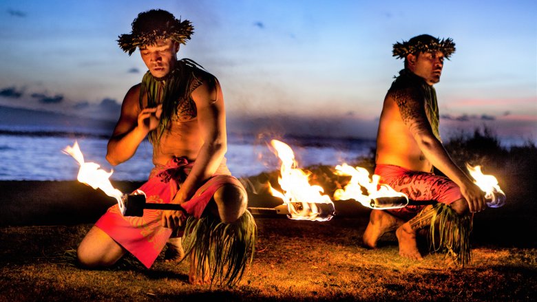 Des hommes hawaïens se préparent à avaler du feu à Maui