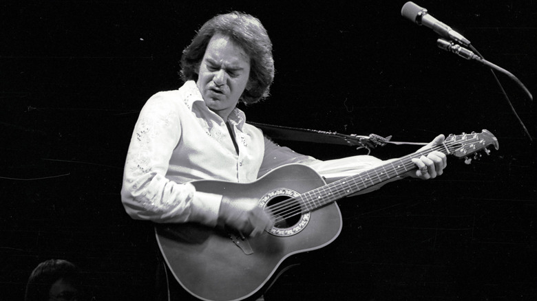 Neil Diamond jouant de la guitare sur scène
