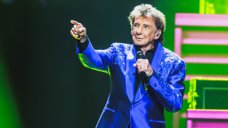 Barry Manilow sur scène pointant le public