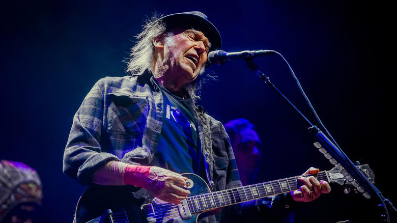 Neil Young sur scène en 2019 chantant et jouant de la guitare