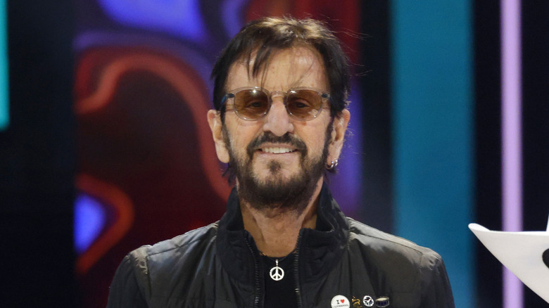 Ringo Starr posant devant un fond coloré