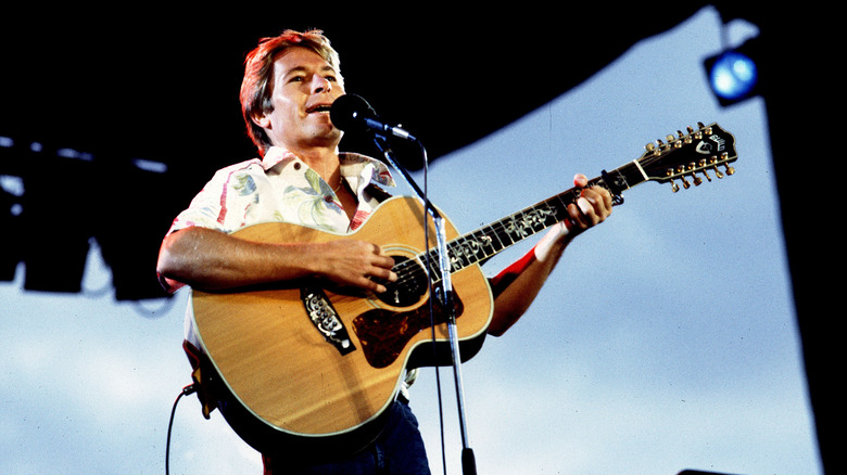 John Denver jouant de la guitare acoustique sur scène