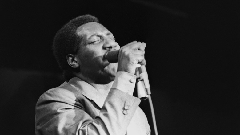 Otis Redding chantant dans un micro sur scène en 1967
