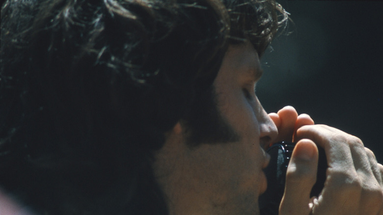 Jim Morrison tenant un micro de près